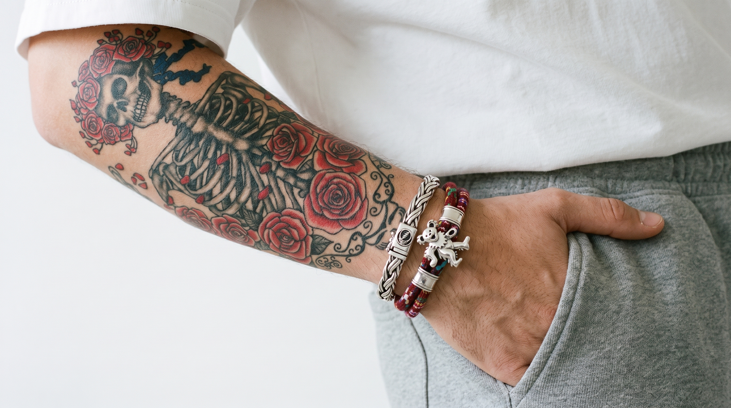 Grateful Dead Official Licensed Collection - sterling silver braided bracelet and Dancing Bear beaded bracelet on a tattooed wrist
