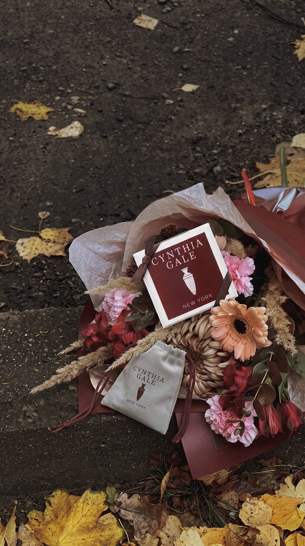 Cynthia Gale New York gift box and grey suede jewelry pouch with an autumn bouquet on a city curb (mobile)